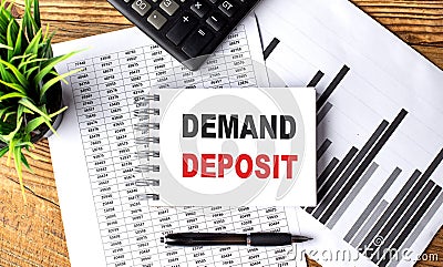 DEMAND DEPOSIT text on notebook on chart with calculator and pen Stock Photo