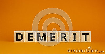 Demerit symbol. The concept word Demerit on wooden cubes. Beautiful orange table, orange background, copy space. Business and Stock Photo