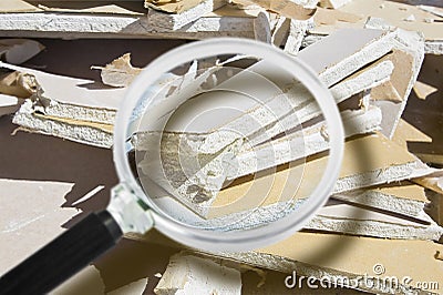 Demolished plasterboard wall, made of plaster and cardboard, with fragments of material and dust in a construction site - focus Stock Photo