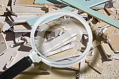 Demolished plasterboard wall, made of plaster and cardboard, with fragments of material and dust in a construction site - focus Stock Photo