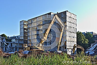 Demolished residential building being torn down by two excavators Stock Photo