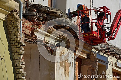 Demolition of an apartment building worker on a forklift using a jackhammer. creates an apocalyptic scene. clearing work after the Editorial Stock Photo