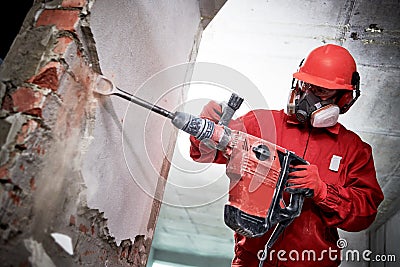 Demolition and construction destroying. worker with hammer breaking interior wall plastering Stock Photo