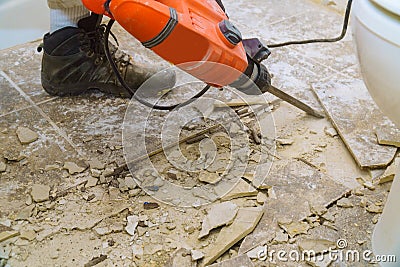 Demolition of old tiles with jackhammer. Renovation of old floor Stock Photo