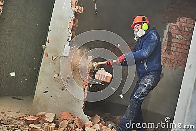 Demolition work and rearrangement. worker with sledgehammer destroying wall Stock Photo