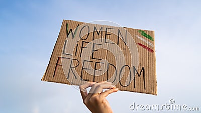 Demonstrator holding Women, Life, Freedom placard Stock Photo