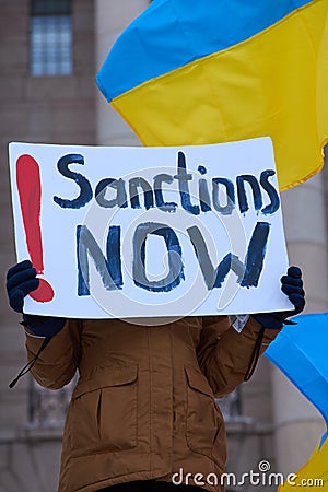 Demonstrator in a rally against Russiaâ€™s military actions and occupation in Ukraine carrying sign Sanctions Now! Editorial Stock Photo