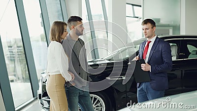 Den intresserade den parmannen och kvinnan talar till chefen i bilåterförsäljare, medan han är träffande dem om den lyxiga automa arkivfilmer Den intresserade den parmannen och kvinnan talar till chefen i bilåterförsäljare, medan han är träffande dem om den lyxiga automa arkivfilmer