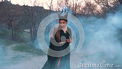 Den kraftiga och skr?mmande flickan i en l?ng kl?nning f?r gr?n smaragd poserar f?r foto i fantasistil, dam med horn p? henne arkivfilmer Den kraftiga och skr?mmande flickan i en l?ng kl?nning f?r gr?n smaragd poserar f?r foto i fantasistil, dam med horn p? henne arkivfilmer