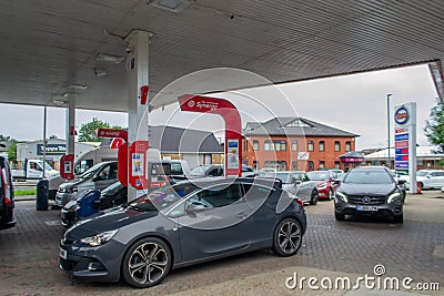 DENHAM, ENGLAND - 25 September 2021: Queue of cars waiting to fill up on fuel outside Esso petrol station amid fuel shortage Editorial Stock Photo