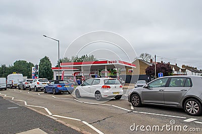 DENHAM, ENGLAND - 25 September 2021: Queue of cars waiting to fill up on fuel outside Esso petrol station amid fuel shortage Editorial Stock Photo