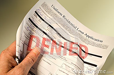 Denied loan application crumpled in hand Stock Photo