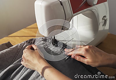 Denim cloth on sewing machine closeup. Seamstress work process concept Stock Photo