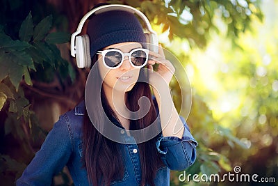 Denim Fashion Girl with Sunglasses Listening to Music on her Headphones Stock Photo