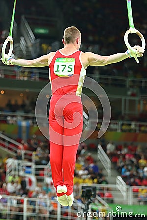 Denis Abliazin of Russian Federation competes at the Men`s Rings Final on artistic gymnastics competition at Rio 2016 Olympic Game Editorial Stock Photo