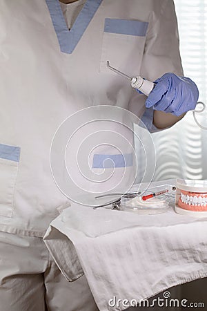 Denstist assistant stays close to the table with stomatological tools. Closeup Stock Photo