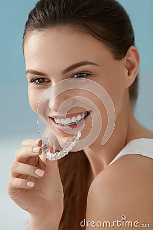 Dental care. Smiling woman using removable clear teeth braces Stock Photo