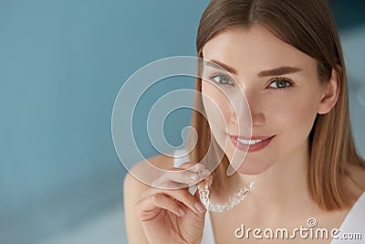 Dental care. Smiling woman using removable clear teeth braces Stock Photo