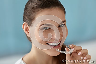 Dental care. Smiling woman using removable clear teeth braces Stock Photo