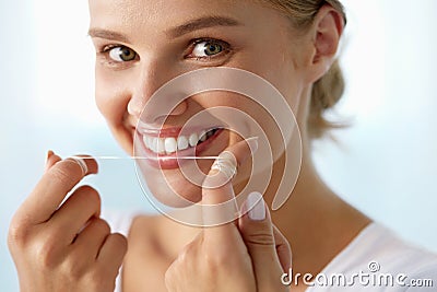 Dental Care. Woman With Beautiful Smile Using Floss For Teeth Stock Photo