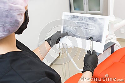 Dental clinic. Reception, examination of the patient. Teeth care. Dentist looks x-ray picture of a patient`s jaw Stock Photo