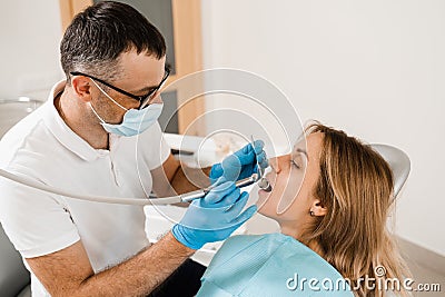 Dental drill. Dentist drilling teeth of woman in dentistry clinic. Dental filling for girl patient. Stock Photo