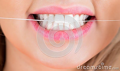 Dental floss. Taking care of teeth. Teeths Flossing. Dental flush - woman flossing teeth. Oral hygiene and health care Stock Photo