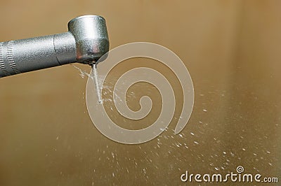 Dental handpiece with a diamond bur and a stream of water cooling the boron. Dental treatment Stock Photo