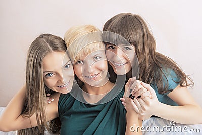 Dental Health and Hygiene Concepts: Three Young Ladies with Teeth Braces Together In Home Environment Smiling and Embracing Stock Photo