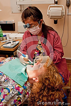 Dental hygienist cleaning patient's teeth Stock Photo