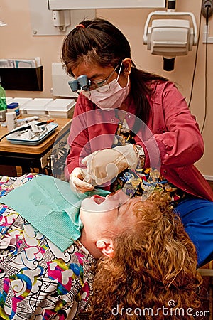 Dental hygienist cleaning patient's teeth Stock Photo