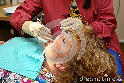 Dental hygienist cleaning patient's teeth Stock Photo