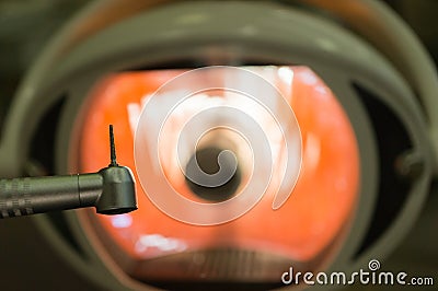 In the dental office - dental handpiece and dental bur close-up against the background of a medical lamp. Concept of dental Stock Photo