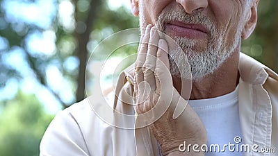 Dental pain, retired man suffering from toothache, teeth prosthetics, dentistry Stock Photo