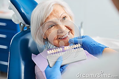 Dental professional matching tooth shade with pensioner teeth Stock Photo