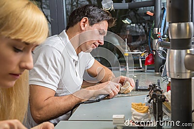 Dental technician polishing dental prosthesis Stock Photo