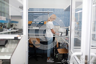Dental technician putting porcelain prosthesis into the oven. Stock Photo