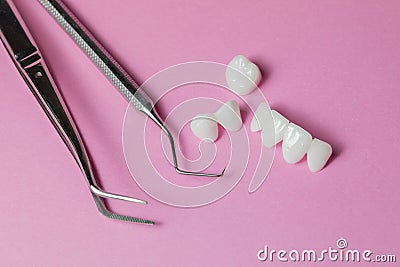 Dental tools with zircon dentures on a pink background - Ceramic veneers - lumineers Stock Photo