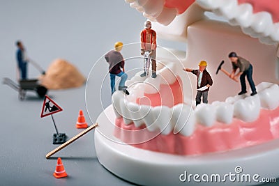 Dental treatment concept - construction workers figurines on tooth model Stock Photo