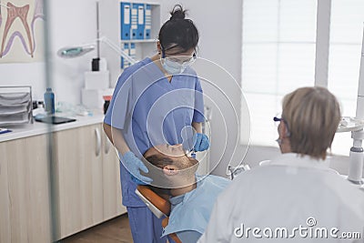 Dental woman nurse applying anesthesia with cotton swab Stock Photo