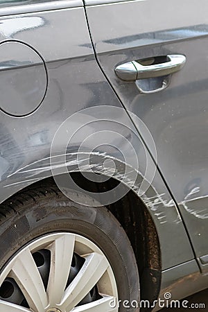 Dented car wing and fender with scratches and bumps after crash and car accident with hit-and-run driving and absconding shows nee Stock Photo