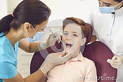 Dentist and assistant check the teeth of a boy child in a dental clinic Stock Photo