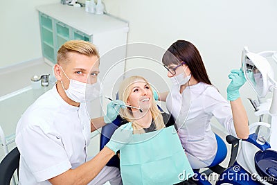 The dentist and assistant are treating teeth to girl Stock Photo