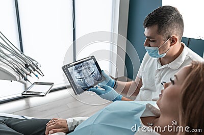 The dentist carefully examines the condition of the patient& x27;s oral cavity on CT and MRI images and develops an Stock Photo