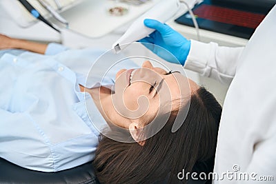 Dentist checking female client mouth health with dental intraoral camera Stock Photo