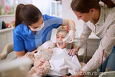 Dentist checking up girlâ€™s teeth Stock Photo