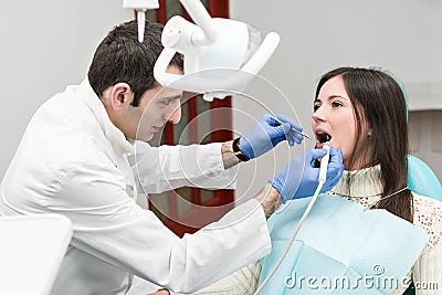 Dentist cleans the patient teeth with ultrasound Stock Photo