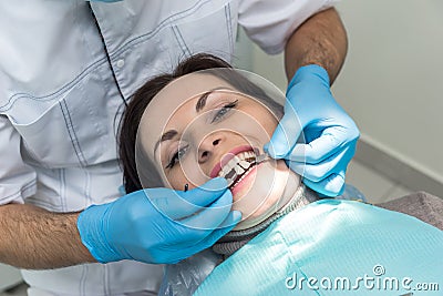 Dentist comparing patient`s teeth color with sampler Stock Photo