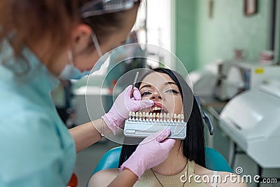 Dentist comparing patient's tooth color sampler in dentistry Stock Photo