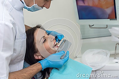 Dentist comparing patient teeth with crown sampler Stock Photo